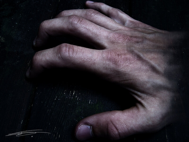 Hand on Dark Surface
