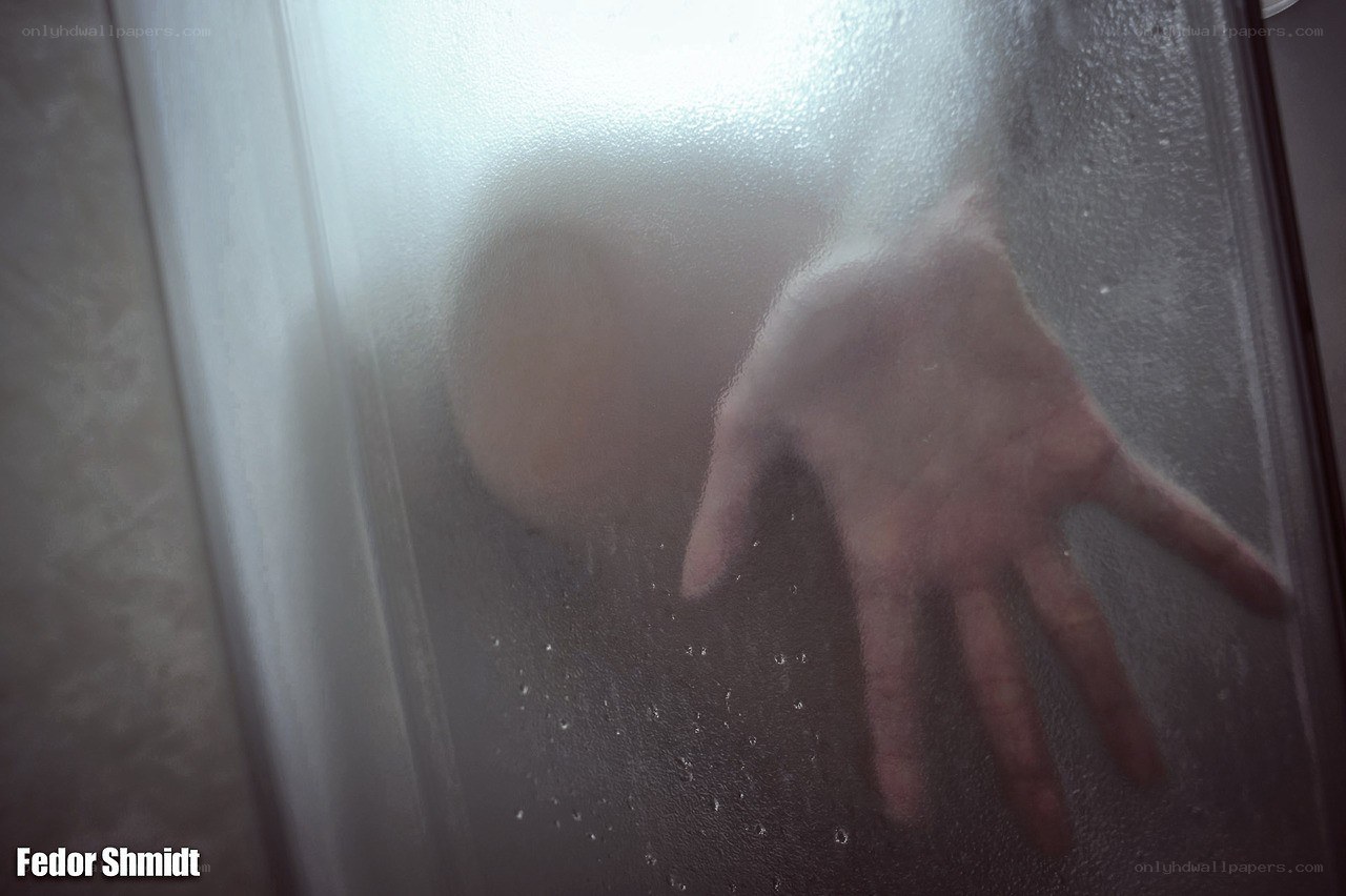 Hand on fogged shower glass