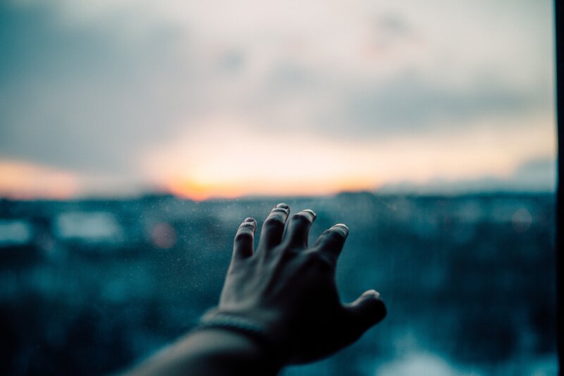 Hand on Glass Window
