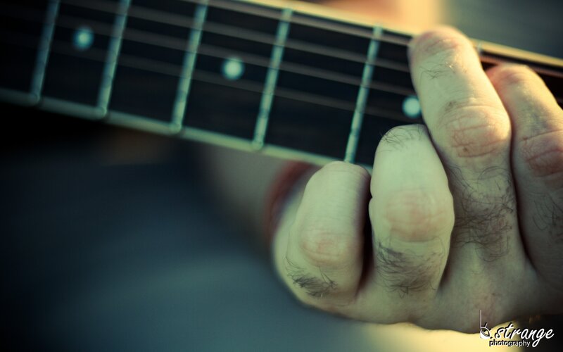 Hand on Guitar Fretboard — Blue, Focused
