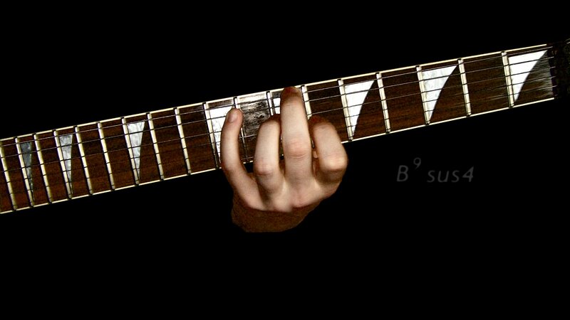 hand on guitar fretboard