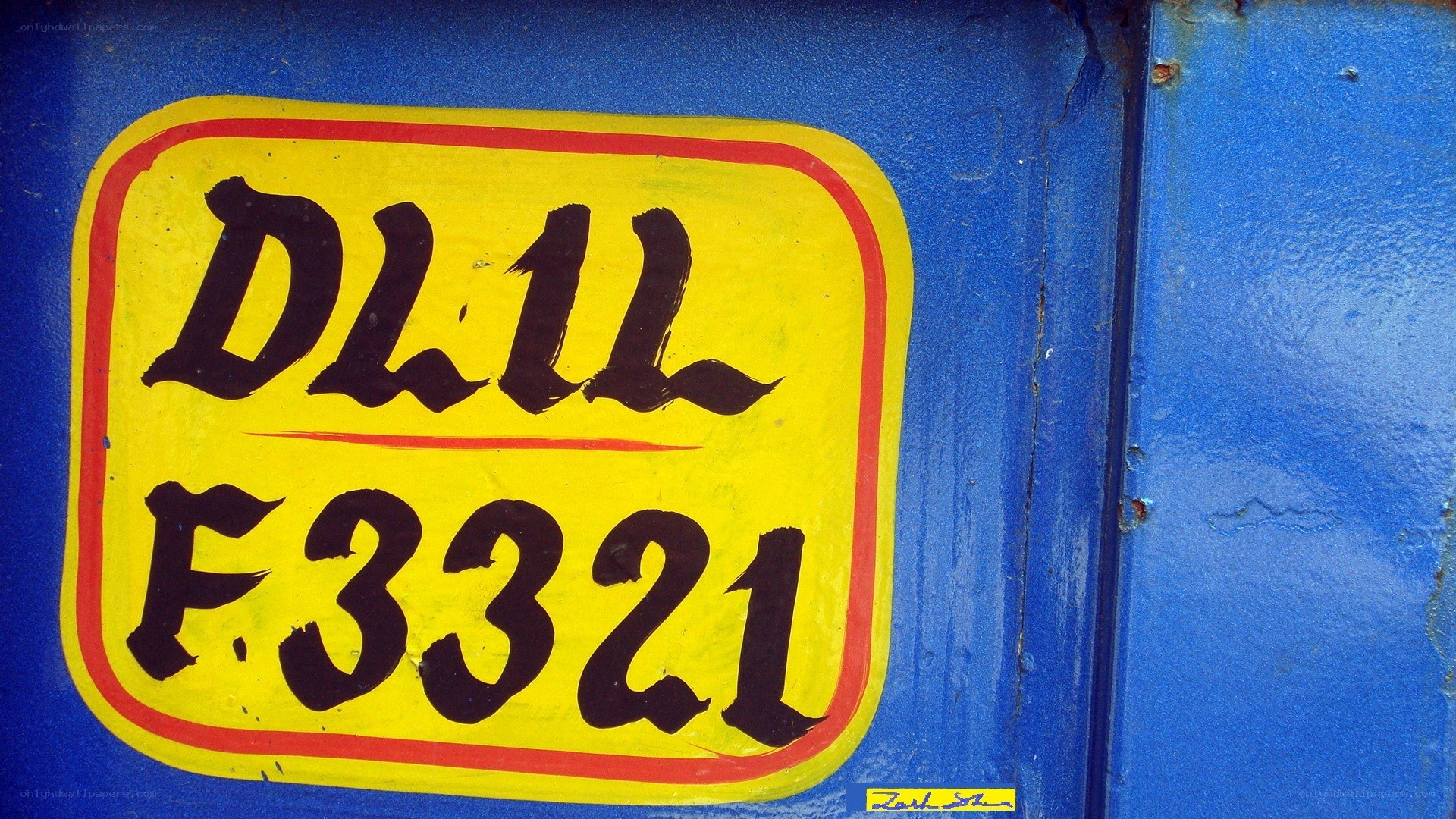 hand-painted license plate on blue surface