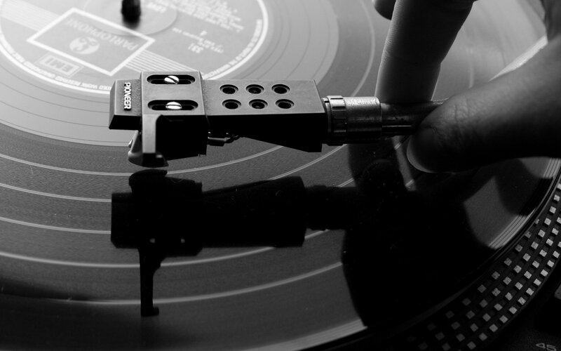 Hand Placing Turntable Needle — Black, Focused, Photograph
