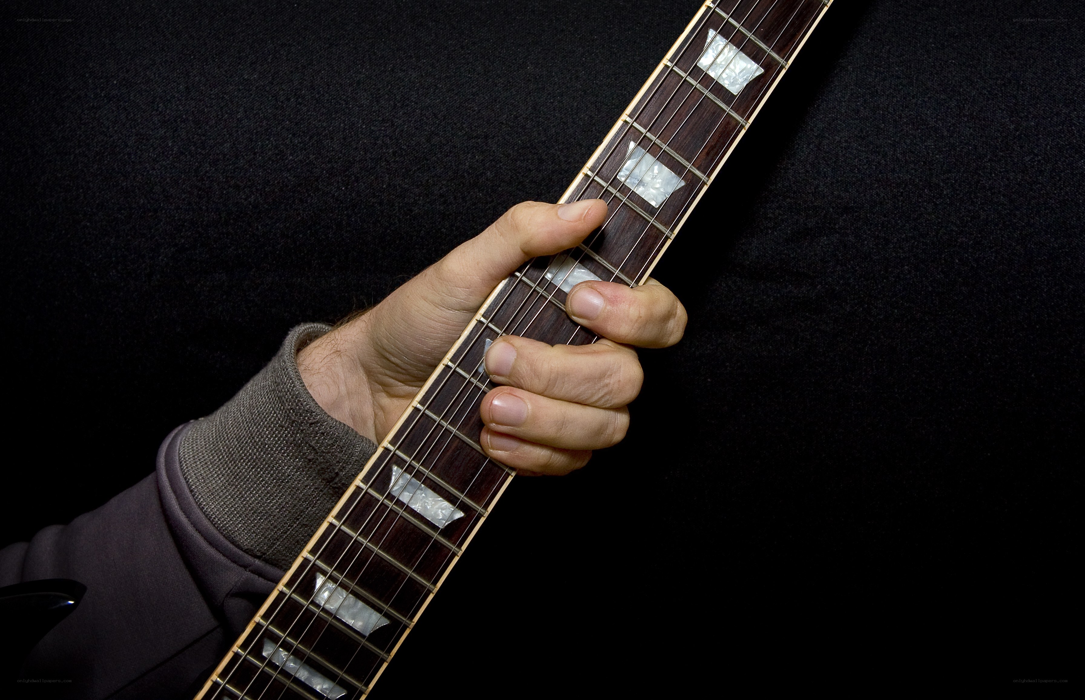 hand playing guitar fretboard