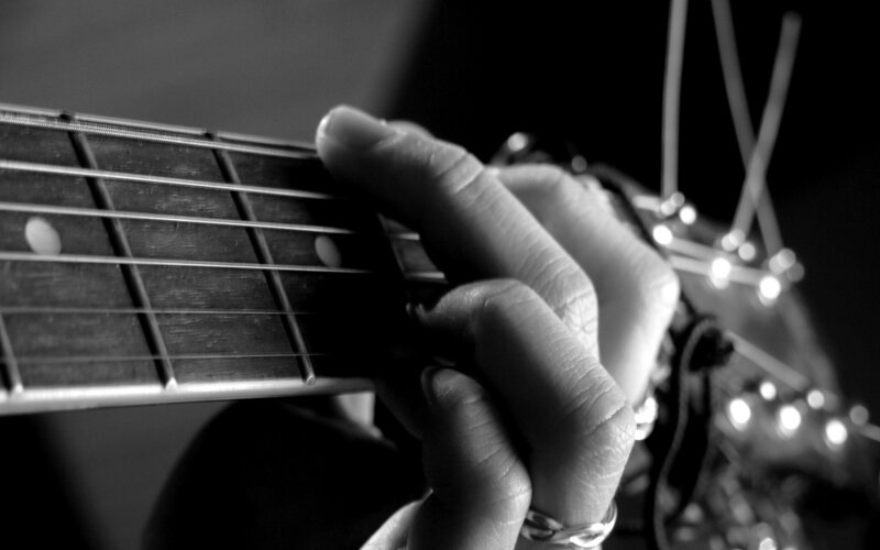 hand playing guitar fretboard