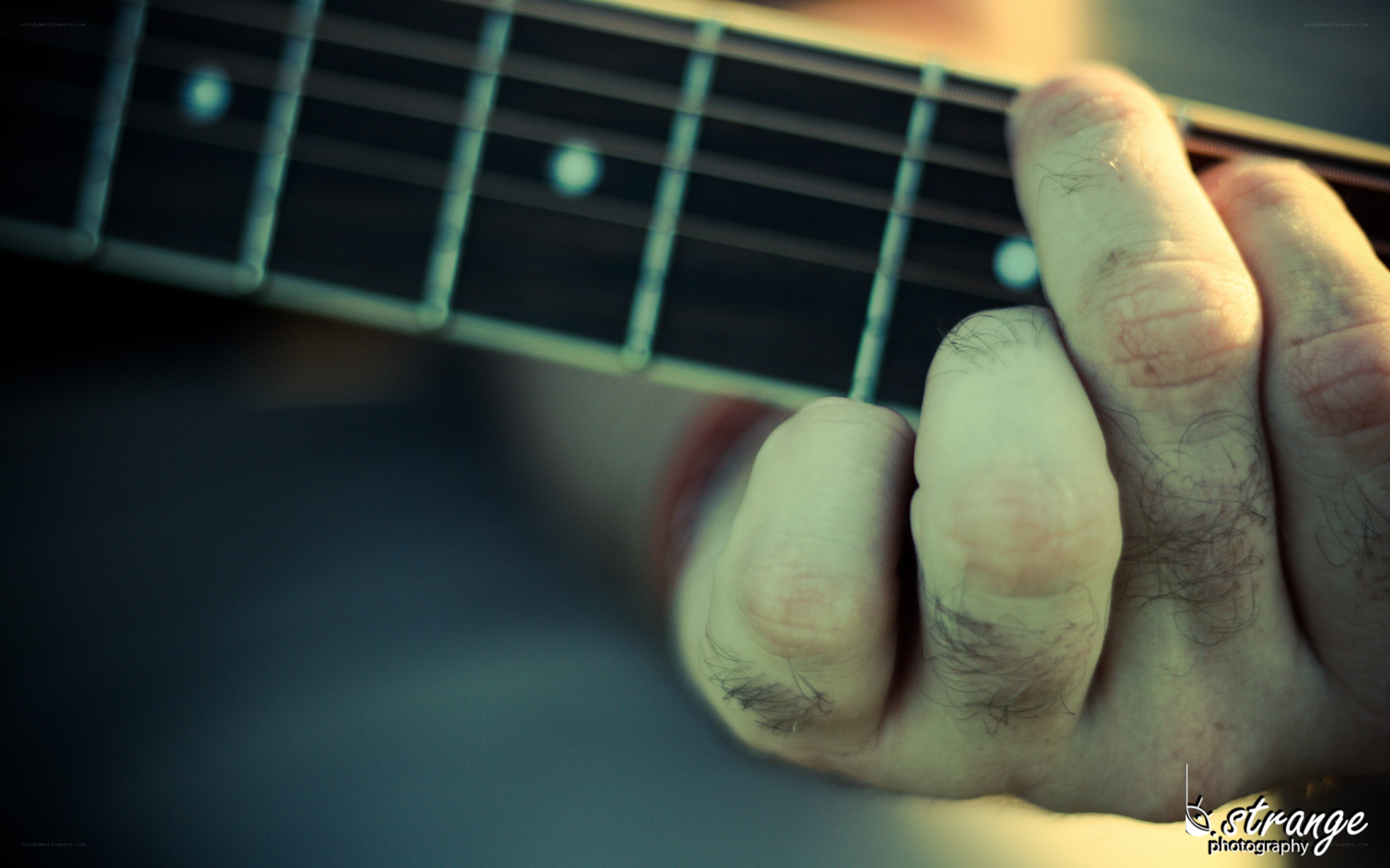 hand playing guitar fretboard