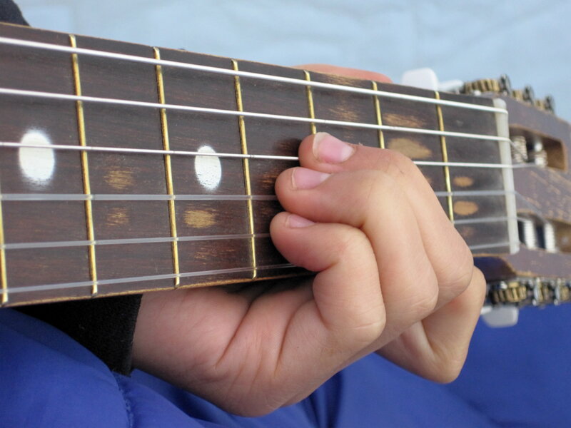 hand playing guitar fretboard