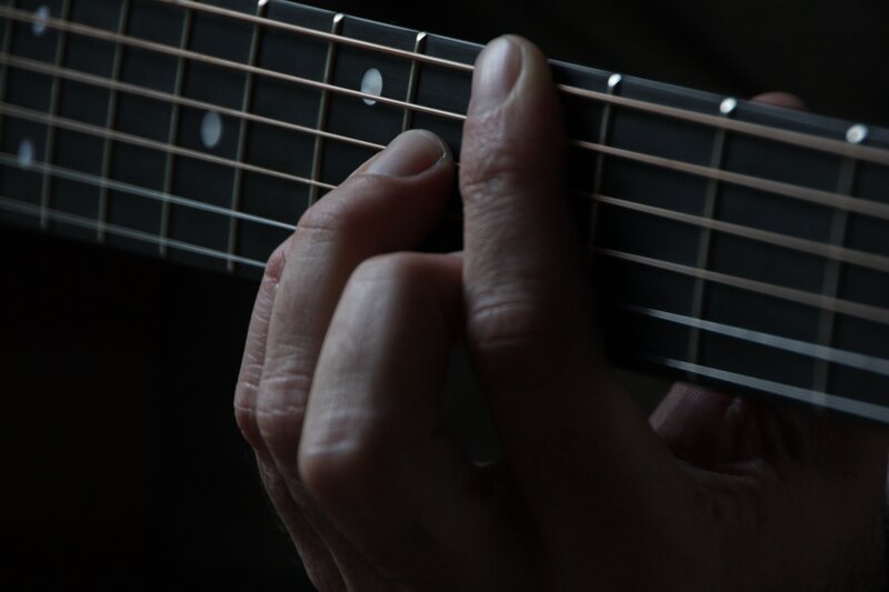 hand playing guitar fretboard
