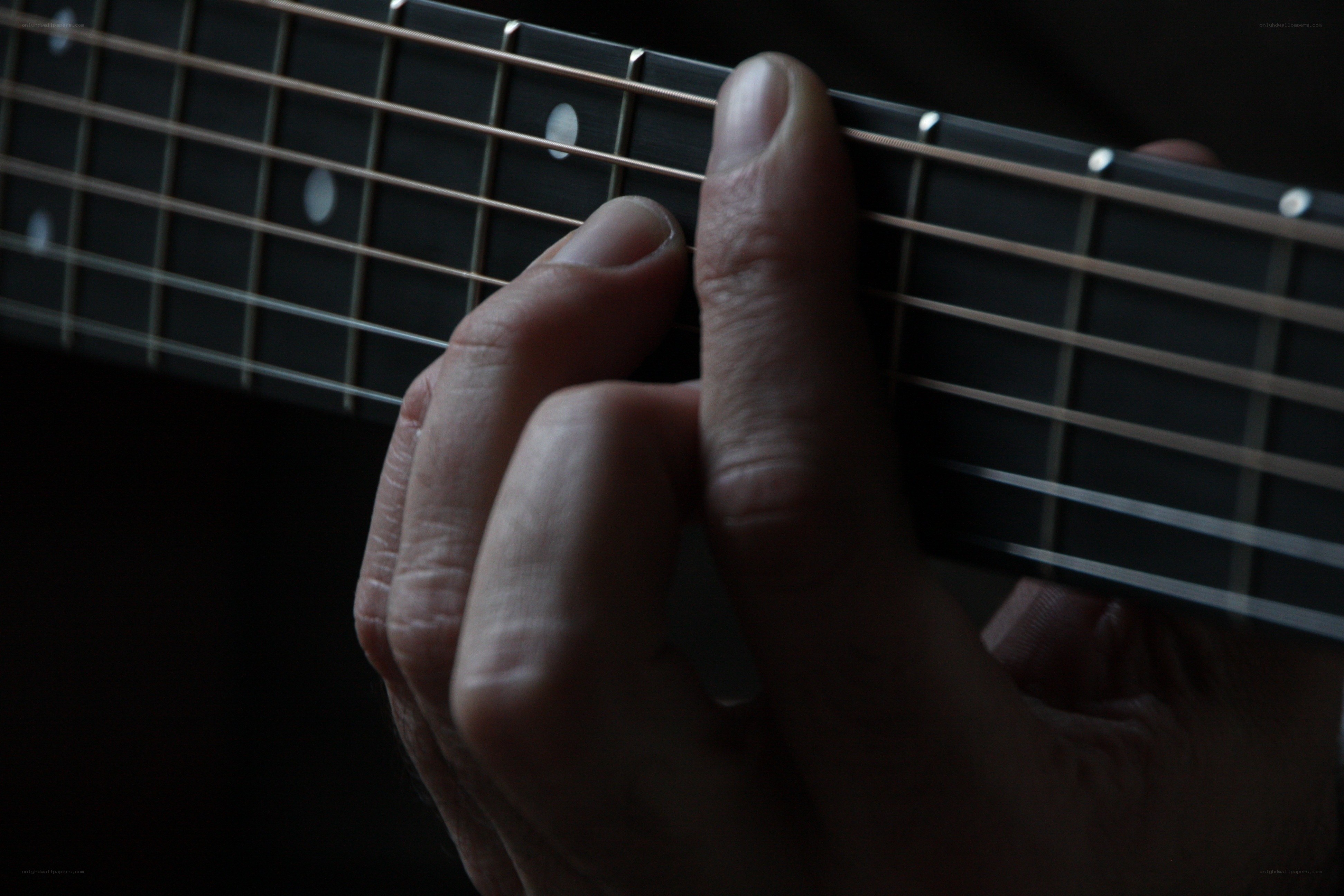 hand playing guitar fretboard
