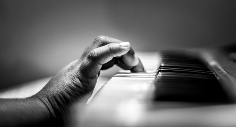 Hand Playing Piano Keys — Black