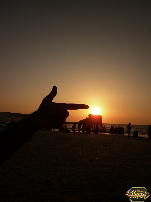 Hand pointing at sunset