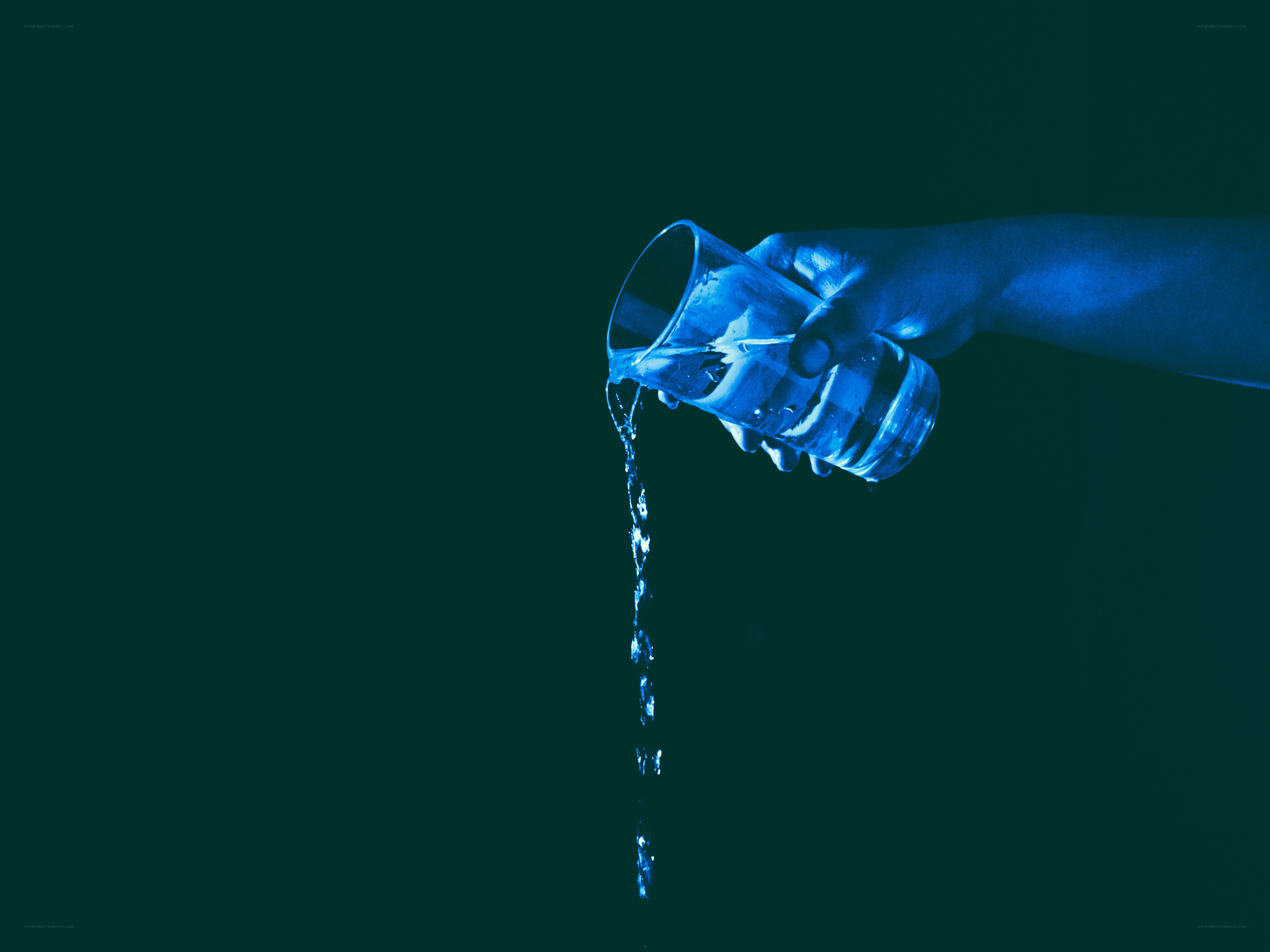 hand pouring water from glass