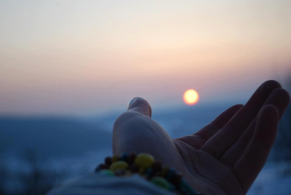 hand reaching for sunset