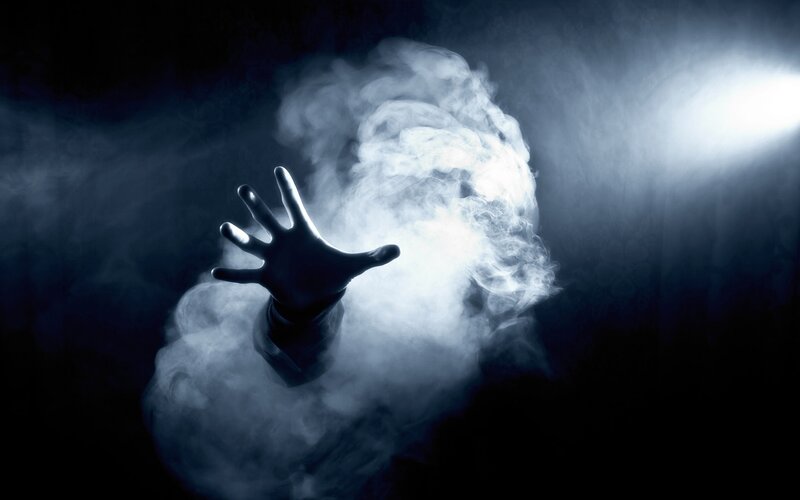 hand reaching through smoke