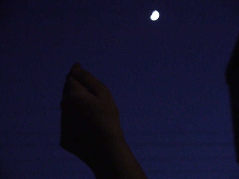 hand reaching toward moon