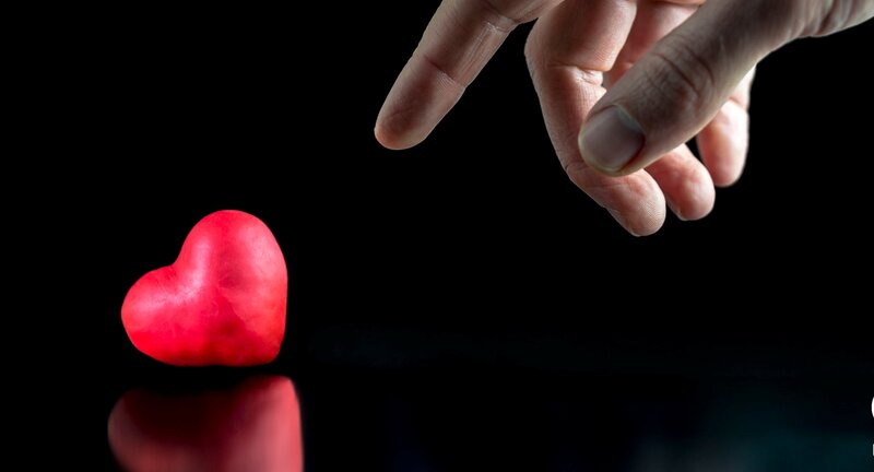 Hand Reaching Toward Red Heart