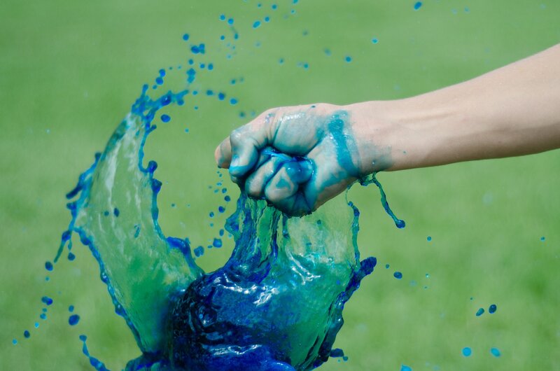 hand splashing blue liquid