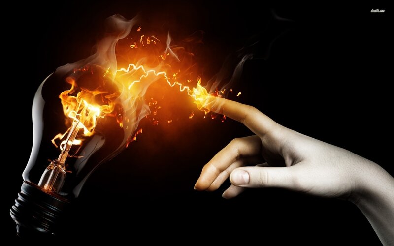 hand touching light bulb flame