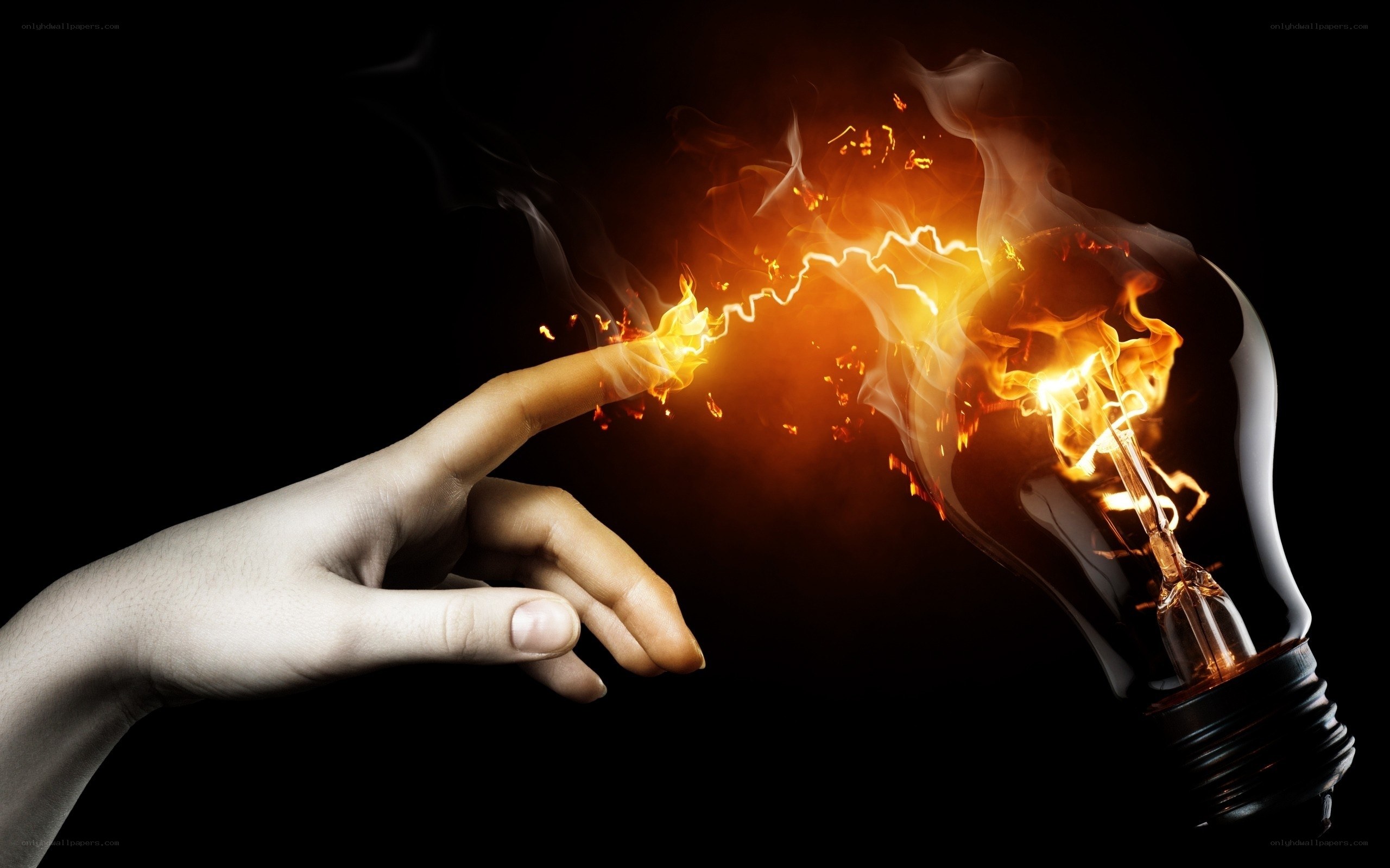 hand touching light bulb with fire