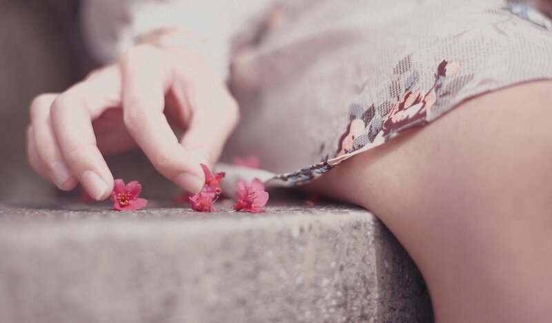 hand touching pink flowers