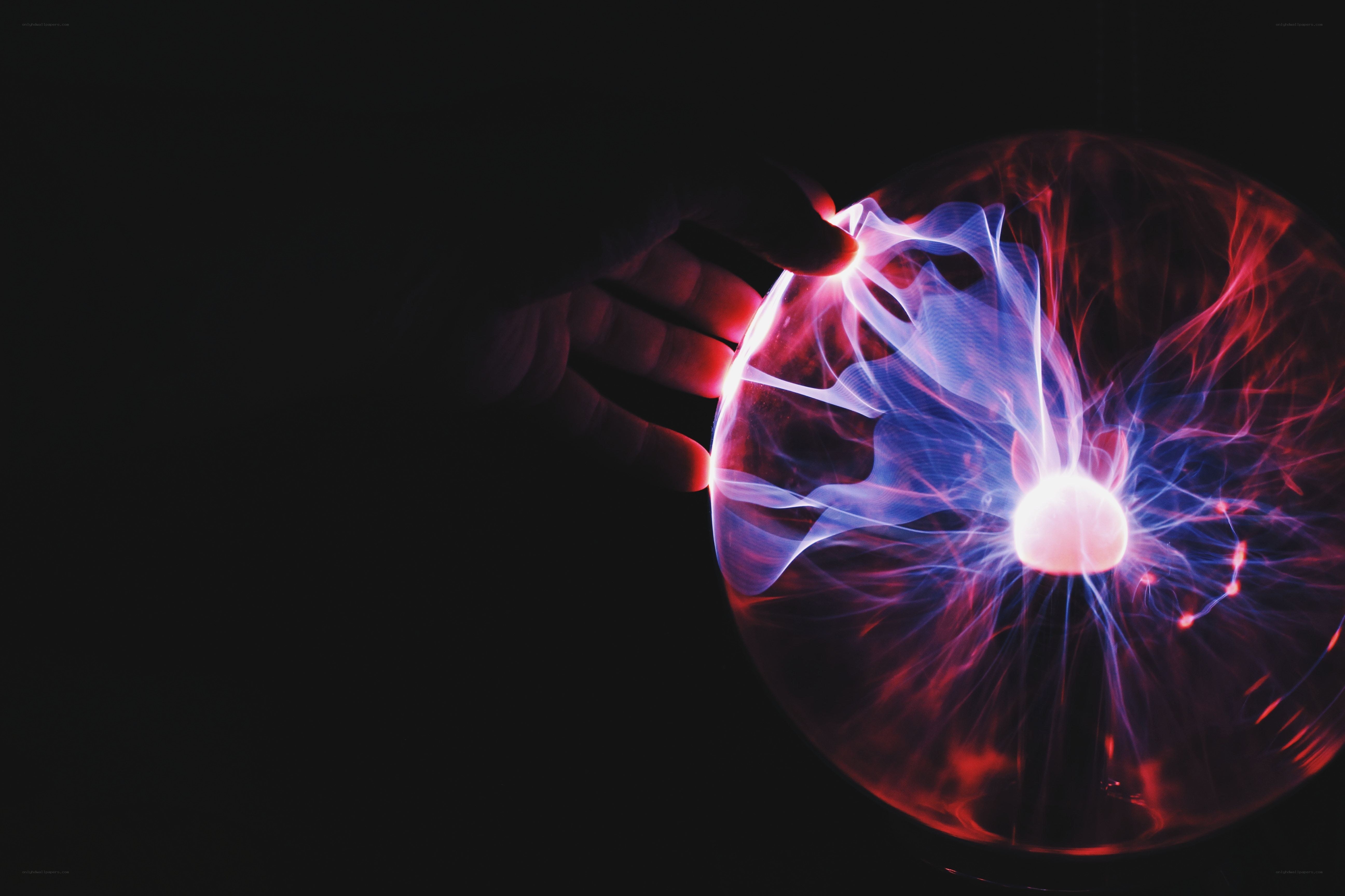 hand touching plasma ball