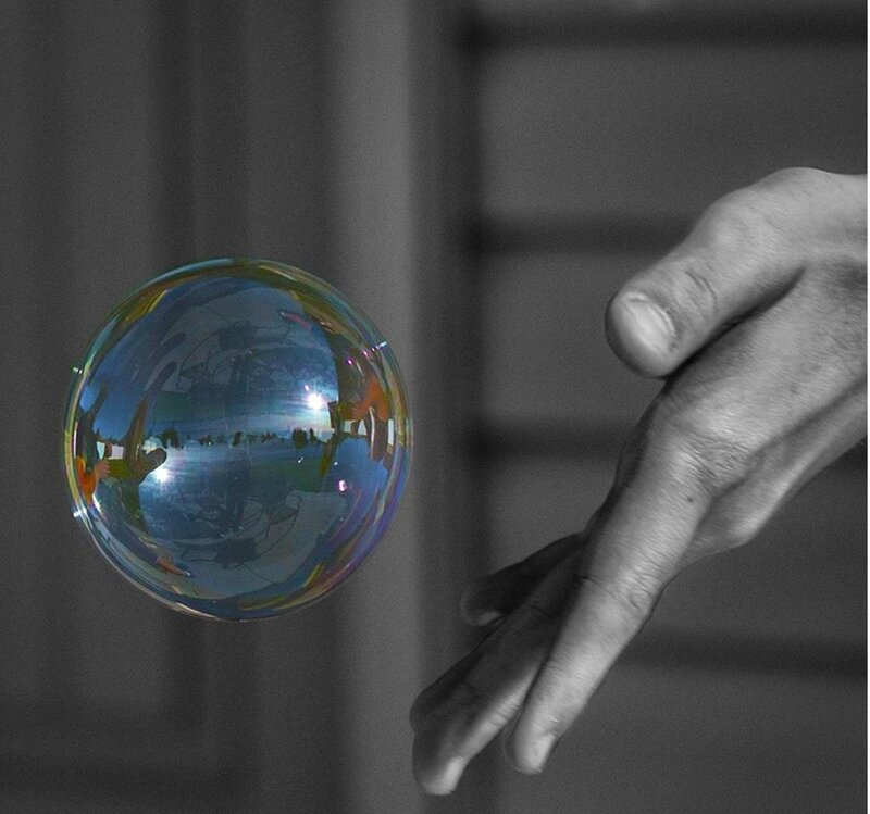 Hand Touching Soap Bubble
