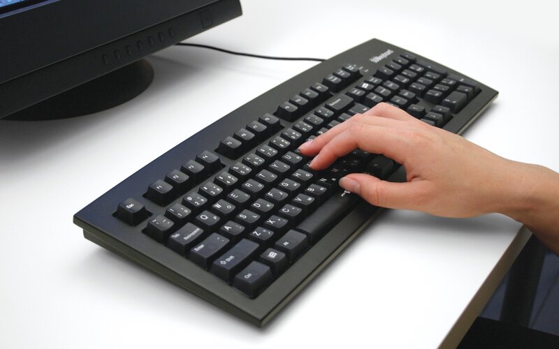 hand using black keyboard