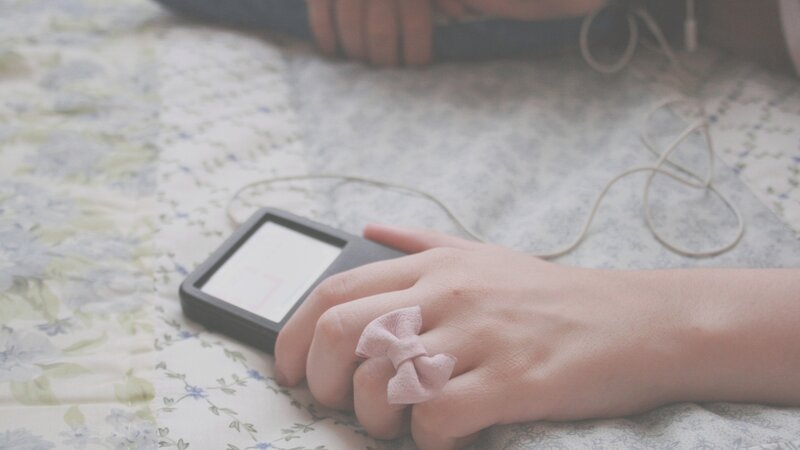 hand with bow ring holding mp3 player
