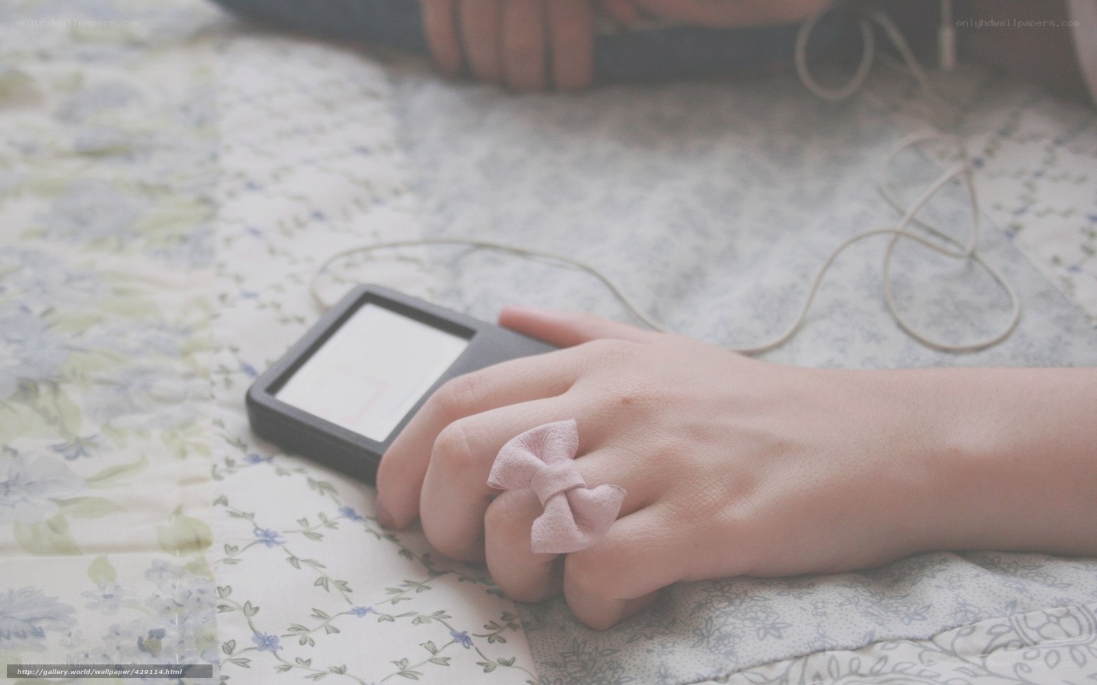 hand with bow ring on bed