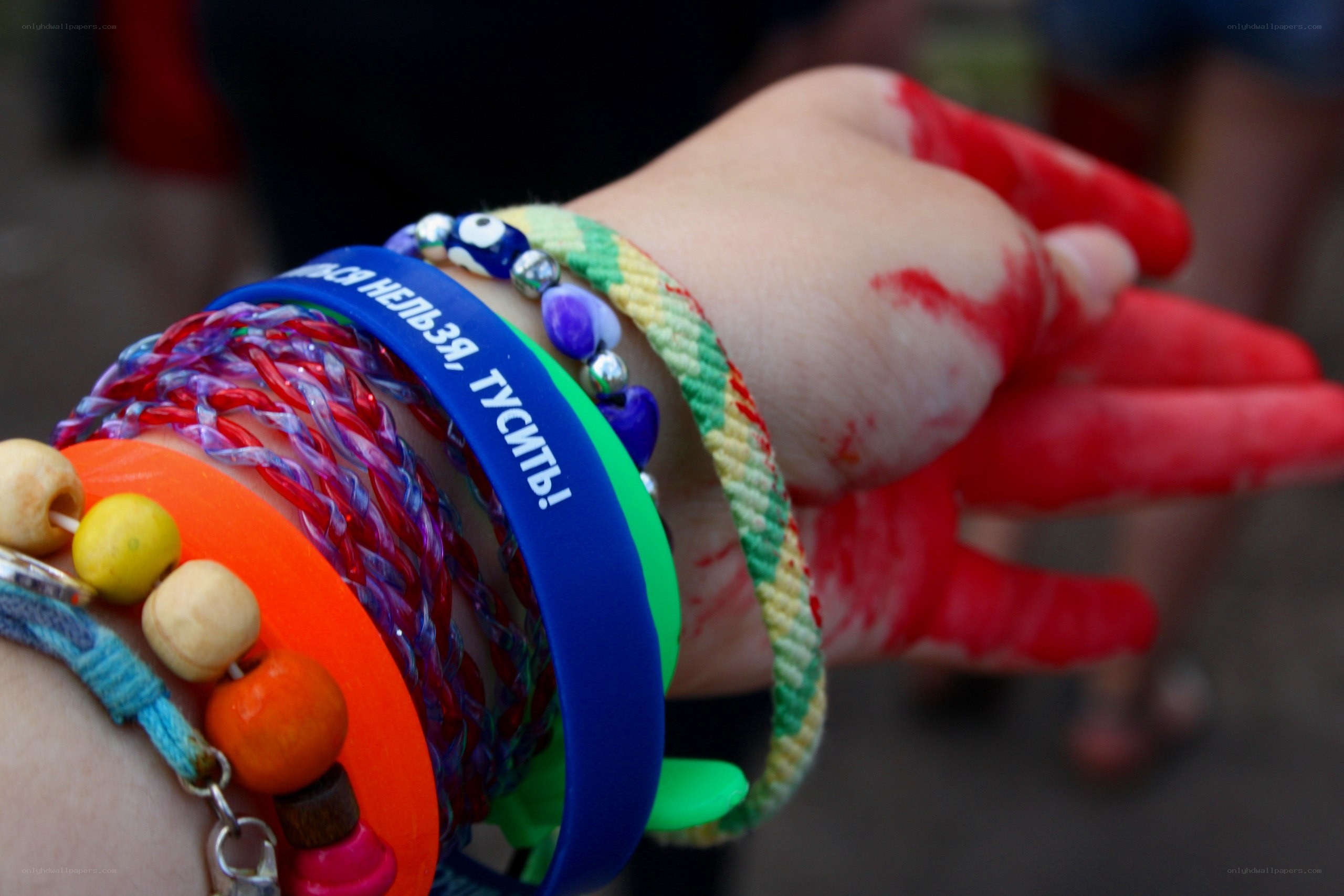 hand with bracelets and red paint