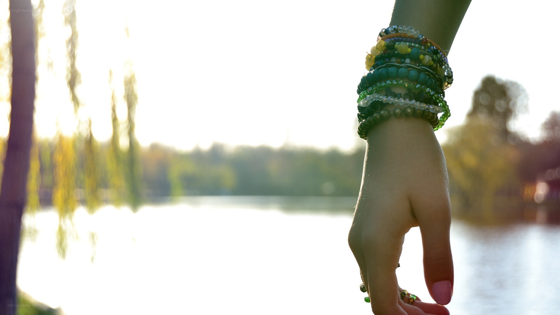 hand with bracelets by water