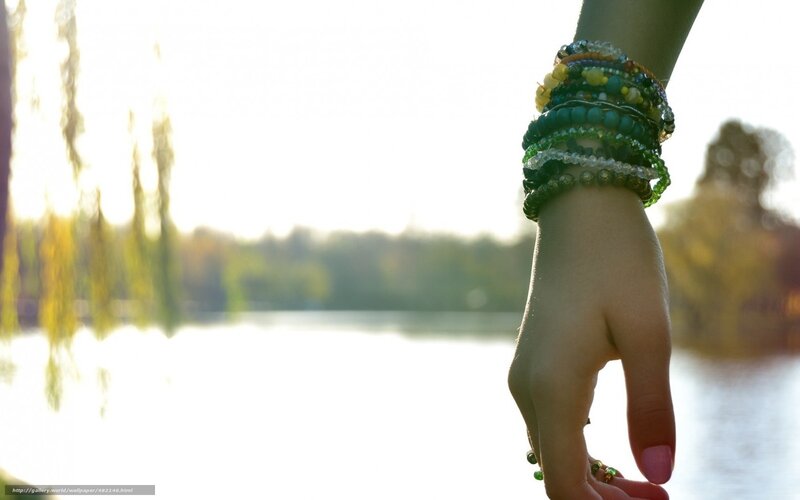 hand with bracelets by water