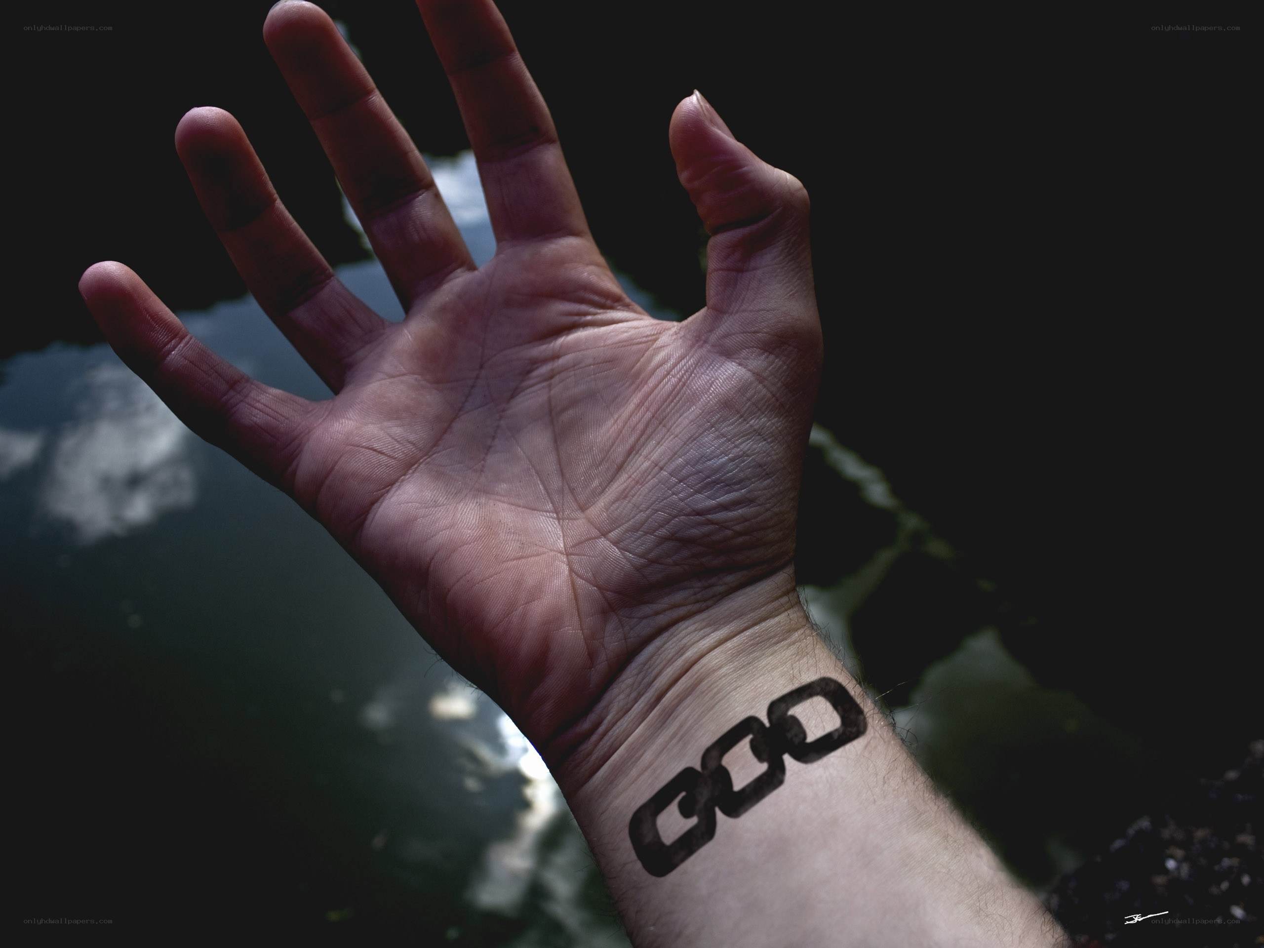 hand with chain tattoo