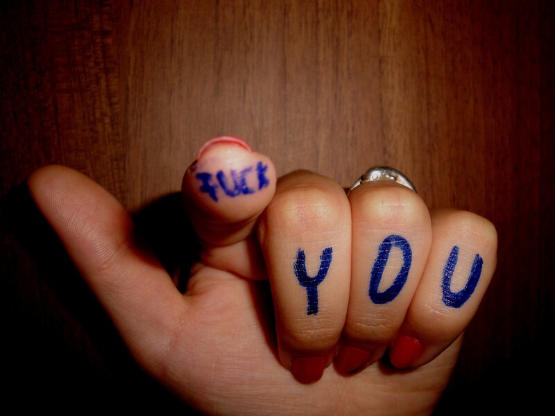 hand with 'fuck you' written on fingers