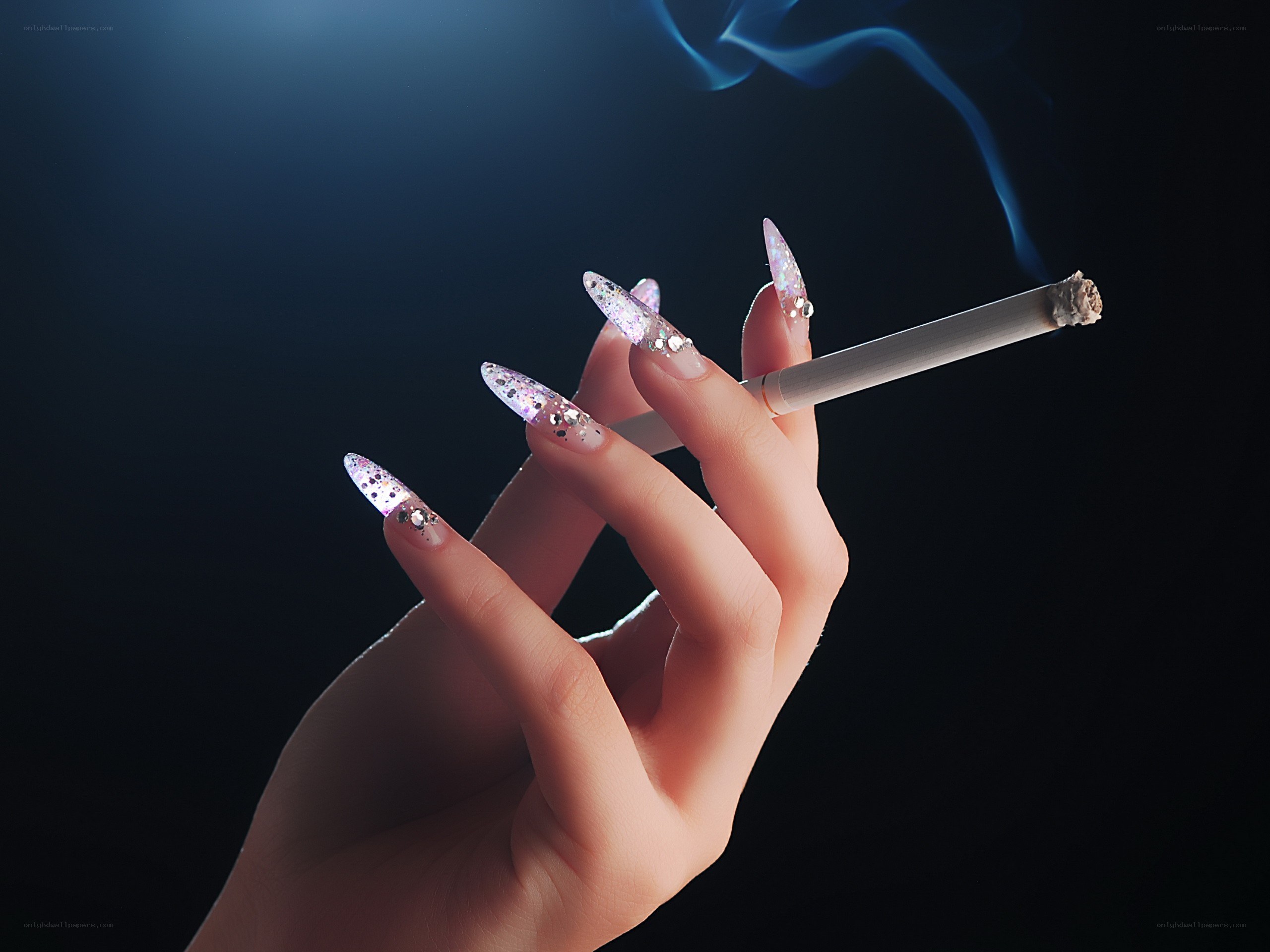 hand with glitter nails holding cigarette