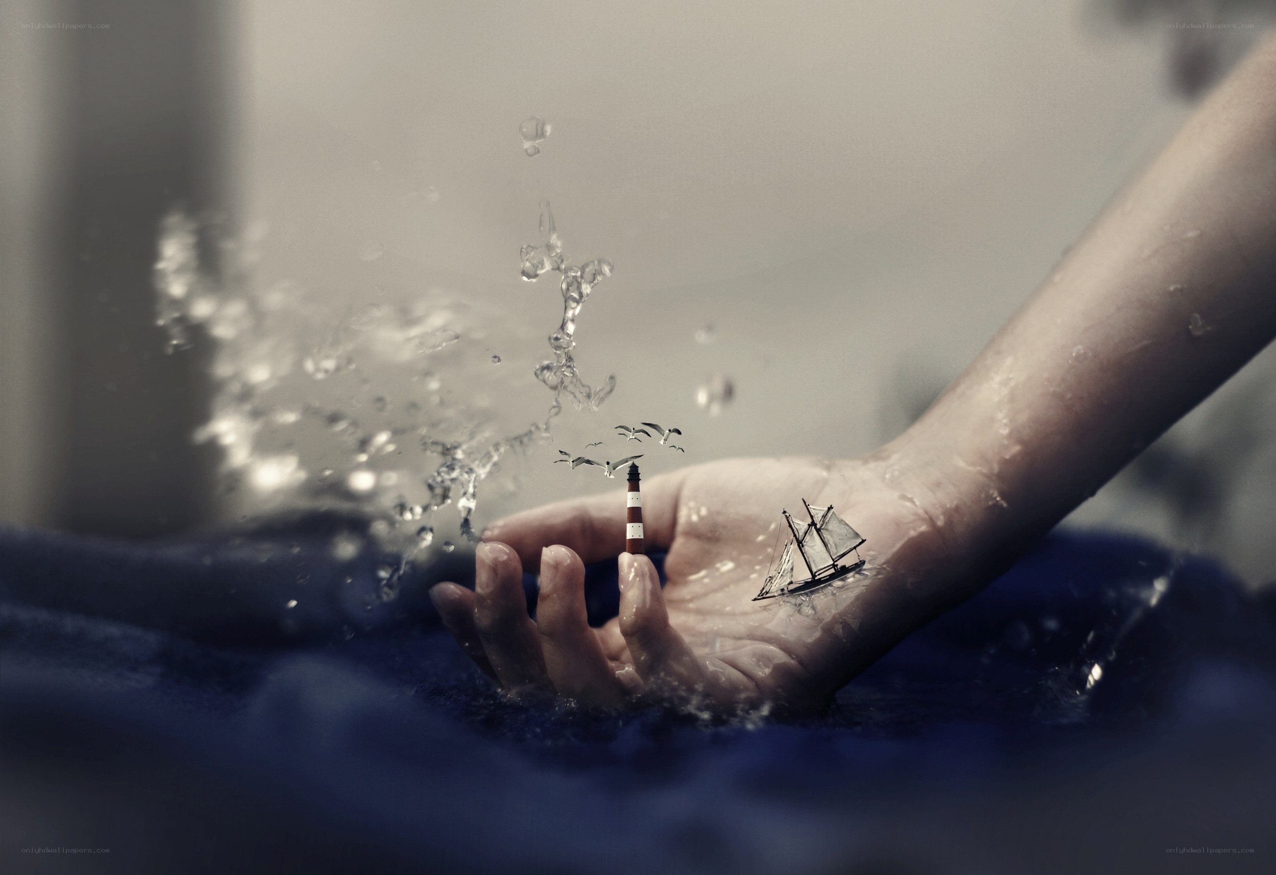 Hand with miniature ship and lighthouse