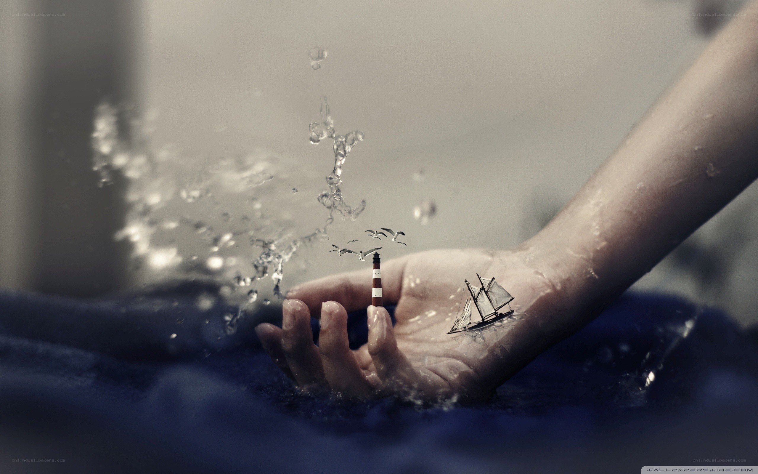 hand with miniature ship and lighthouse
