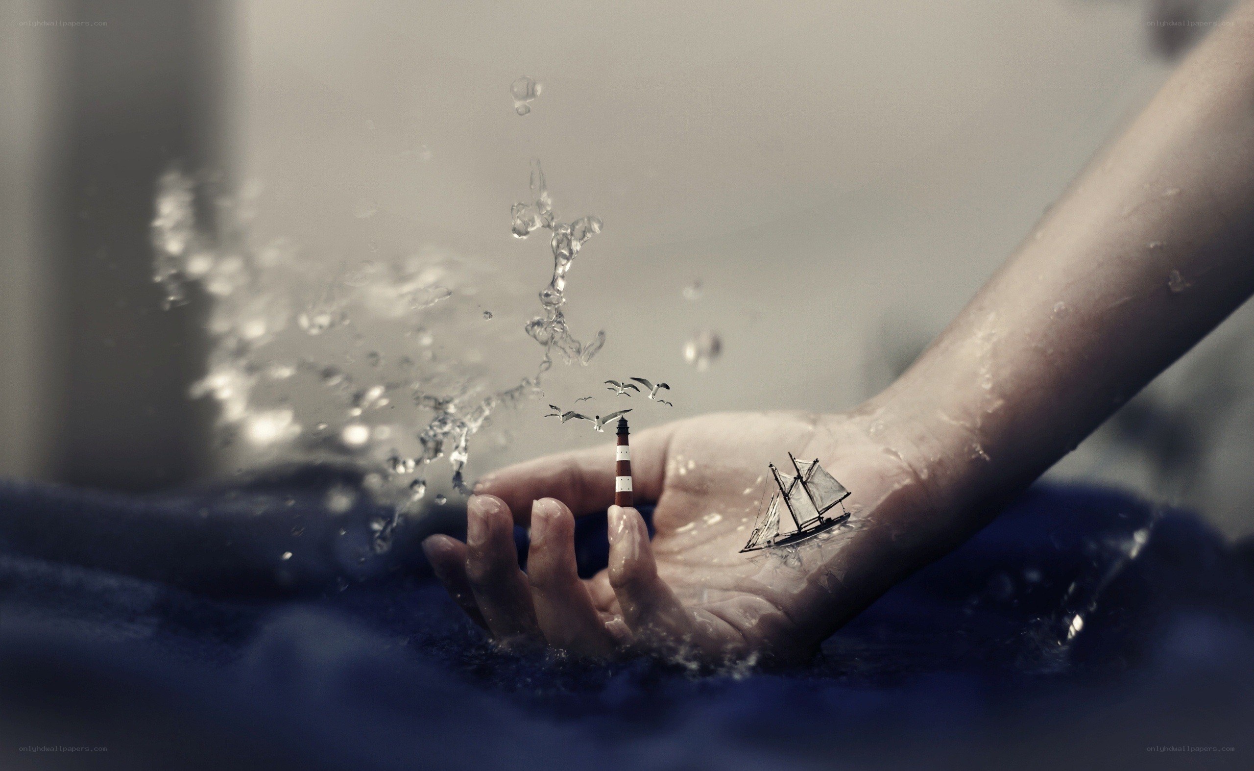 hand with miniature ship and lighthouse