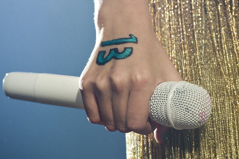 hand with number 13 holding microphone