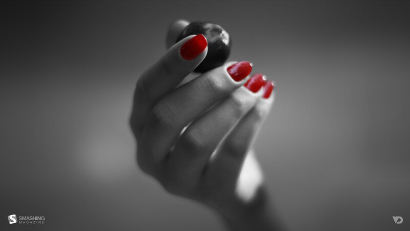 hand with red nails holding berry