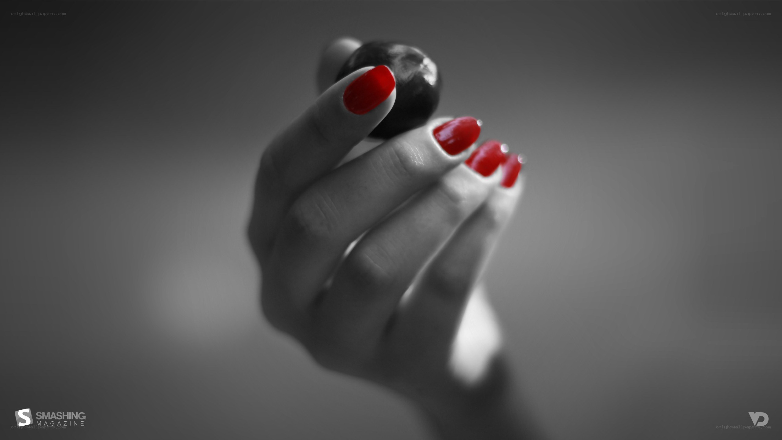 hand with red nails holding berry