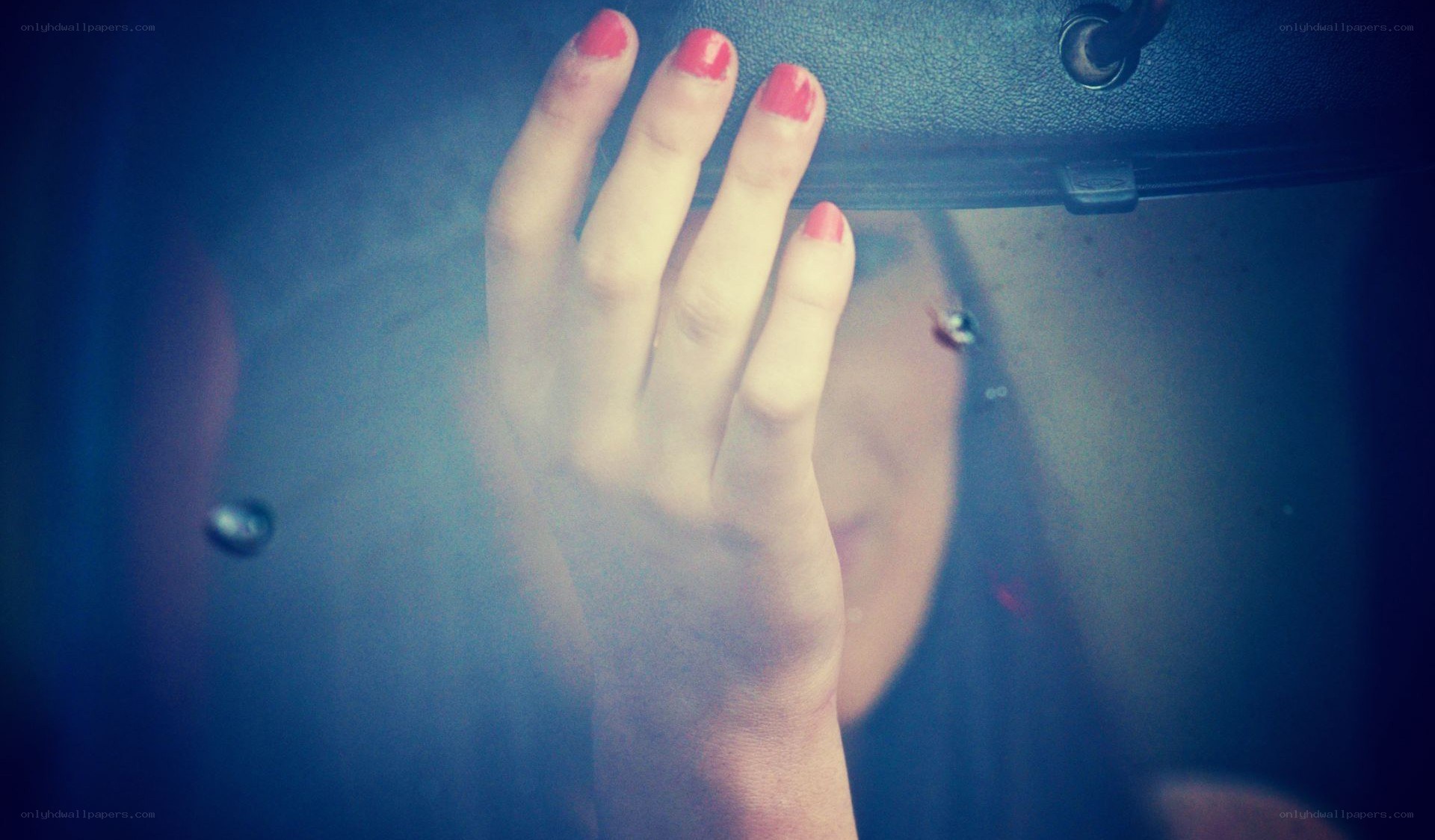 hand with red nails on car interior