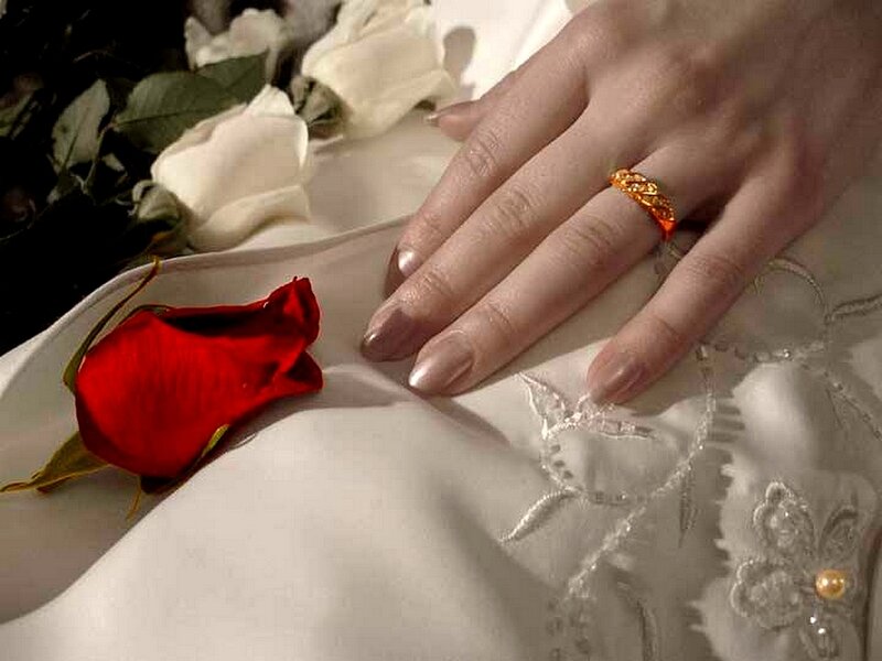 hand with ring and rose petal