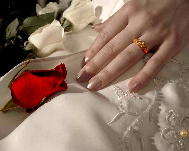 Hand with ring and rose petals