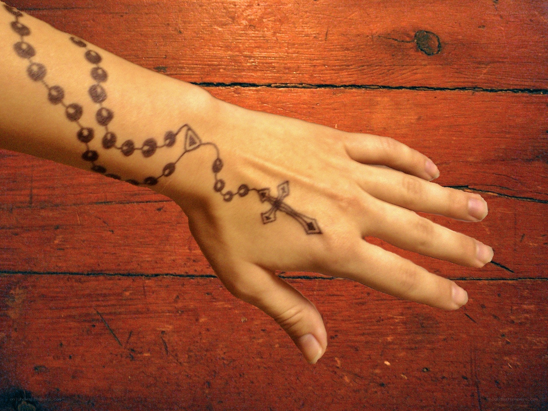 Hand with rosary tattoo