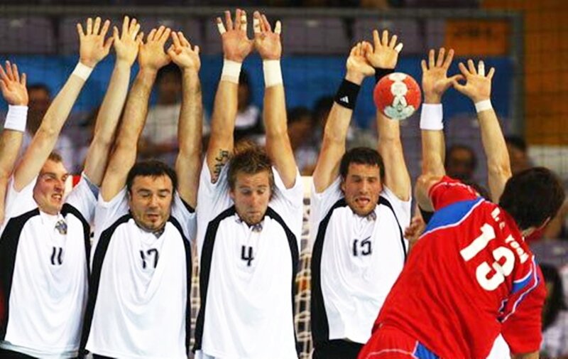 handball players blocking shot