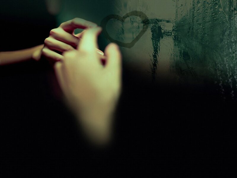 hands drawing heart on foggy glass