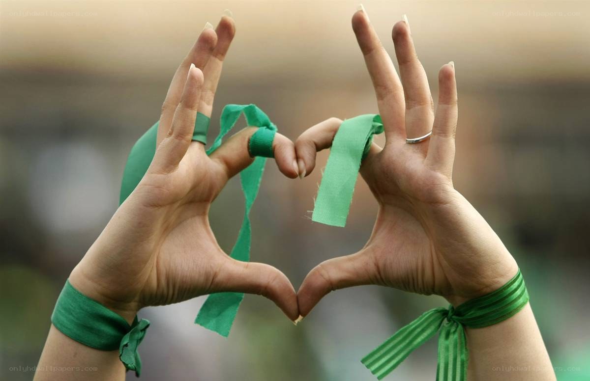 Hands forming a heart with green ribbons