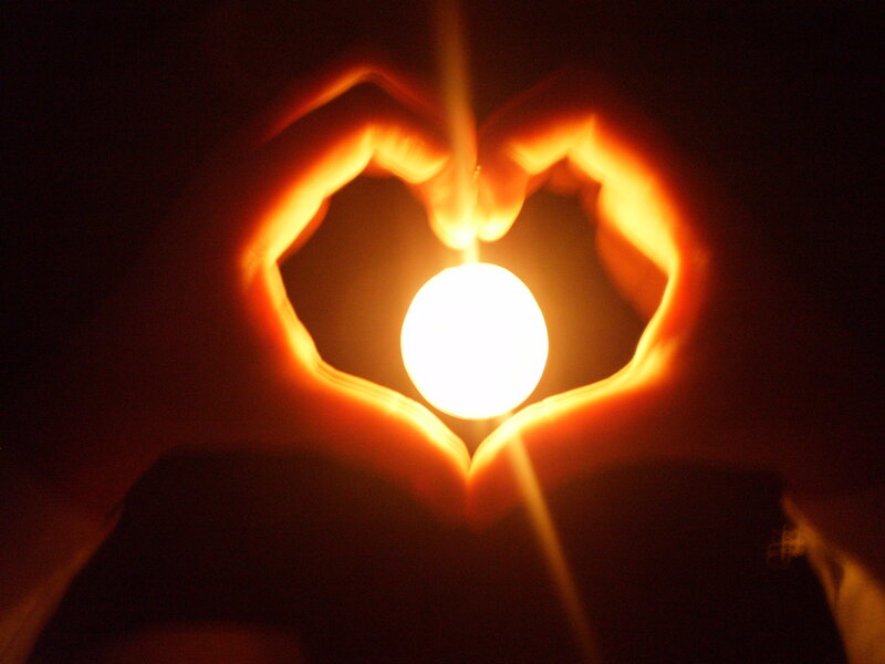 hands forming heart with light