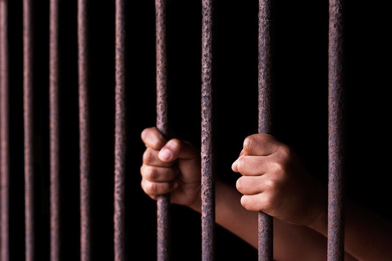 Hands Gripping Prison Bars — Black, Dramatic